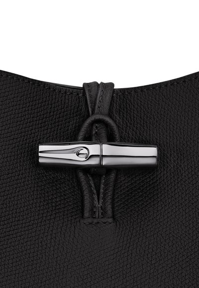 Schwarze Lederhandtasche mit strukturiertem Oberflächen, ausgestattet mit einem metallischen Verschluss und einer gedrehten Kordel für den Verschluss an der Oberseite.