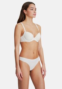 Wit lingerie set bestaande uit een licht gewatteerde beha met bloemenkant en geruit textuur, gecombineerd met bijpassende geruite slips.