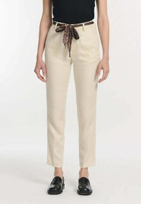 Beige, maßgeschneiderte Hose mit hoher Taille, ausgestattet mit einem dekorativen braunen Leopardendruck-Gürtel. Der Stoff hat eine glatte Textur und einen geraden Schnitt.