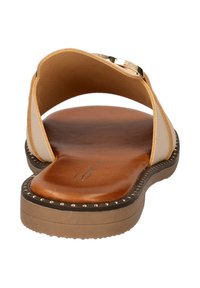 Tan slide sandaal met een zachte leren voetbed, beige banden en decoratieve stiknaad langs een gevoerde zool. Versterkt met een metalen gesp.