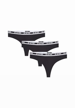 Tres tangas negras de mujer con cinturillas blancas que muestran repetidamente el logo G-STAR en letras negras.