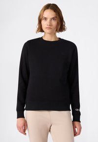 Sudadera negra de tejido suave, con cuello redondo, mangas largas y un pequeño logo en el pecho y la manga. Diseño sencillo.