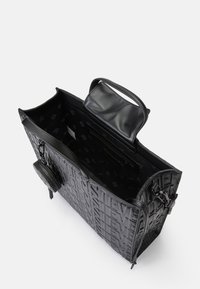 Sort prægede læder tote bag med tekstureret logo, rummeligt interiør, lynlåslomme og flad topstrop. Inkluderer en aftagelig pung.