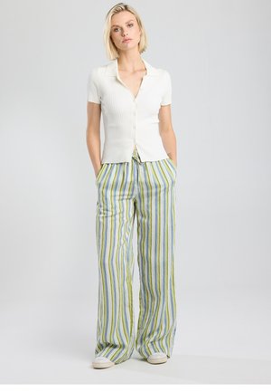 Witte geribbelde top met korte mouwen en knopen, gecombineerd met losse broek met meerkleurige strepen in groen, blauw en wit. Casual pasvorm met zakken.