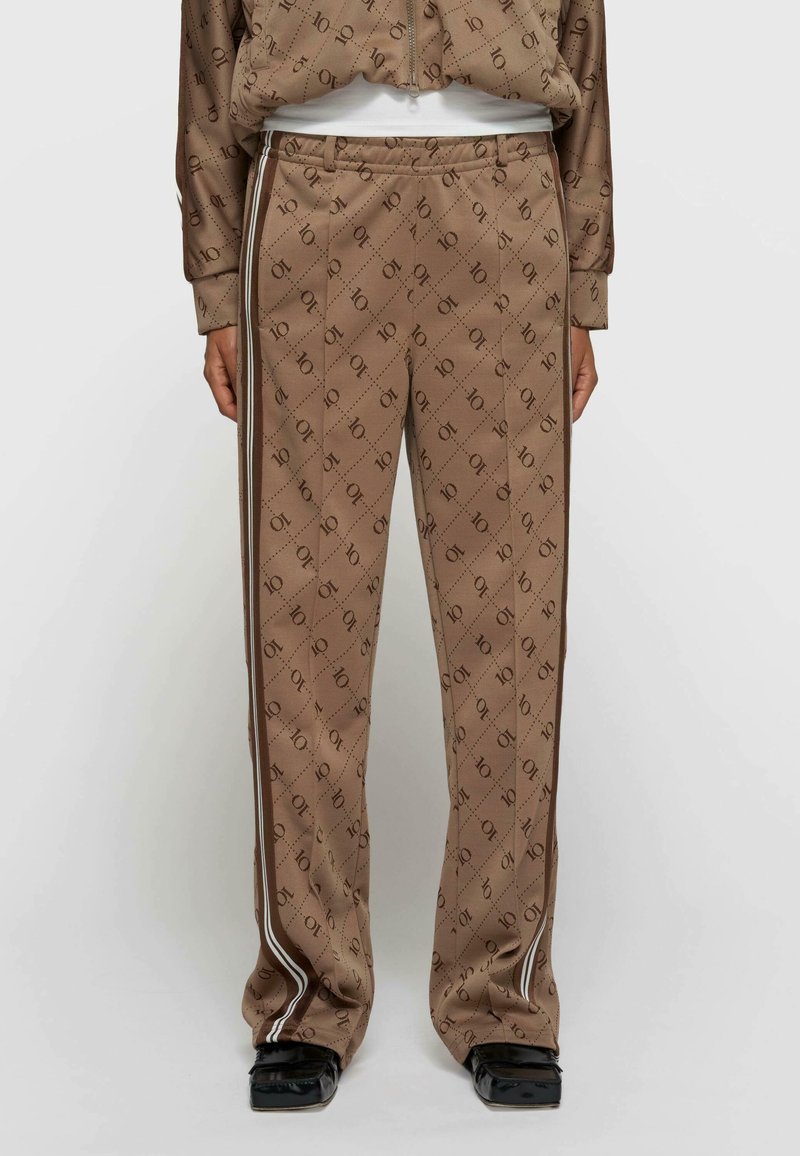 Brązowe wzorzyste spodnie dresowe z miękkiego materiału, z diagonalnym nadrukiem logo, bocznymi paskami i luźnym krojem dla wygody.