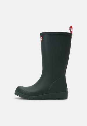 Botte de pluie en caoutchouc noire mi-mollet avec semelle texturée, bout arrondi, languette rouge à l'arrière et petit logo rectangulaire près du haut.