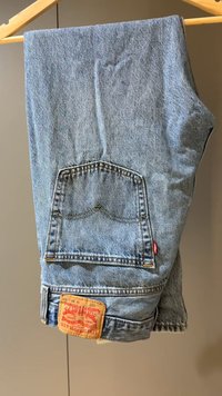 Blauwe spijkerbroek met een klassieke snit, voorzien van een achterzak met gestikte details en een bruin label op de tailleband.