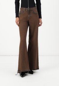 Brown flared jeans with a high waist, featuring front pockets and frayed hems. Made of denim with a smooth texture and a subtle sheen.
