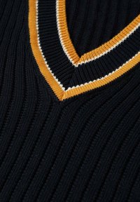 Nahaufnahme von schwarzem geripptem Stoff mit einem V-Ausschnitt, der mit senfgelben und weißen Streifen verziert ist.