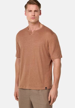 Camiseta de manga corta marrón con una textura sutil y escote en forma de V, hecha de una tela ligera. Presenta una etiqueta en el dobladillo.