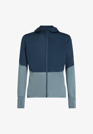 Huvjacka i mörk marinblått och ljusblått, med strukturerat tyg, dragkedjestängning och åtsittande ärmar. Tvåfärgad design med slät finish.