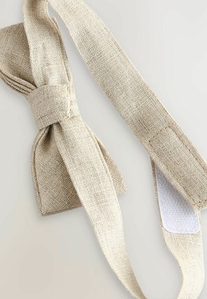 Smėlio spalvos lino peteliškė su tekstūruota audinių, centrinėje dalyje surišta mazgu ir su ilgu dirželiu reguliavimui. Komplekte yra lipnus užsegimas.