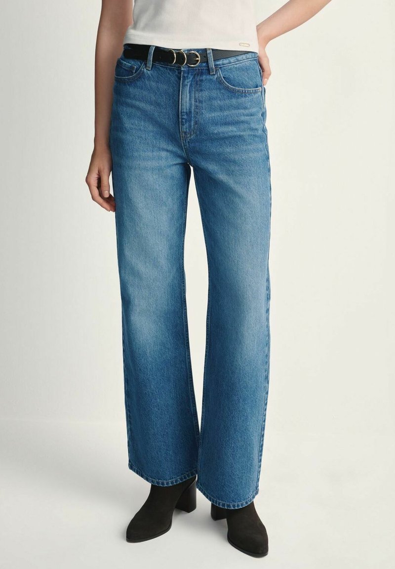 Jasnoniebieskie dżinsy z szerokimi nogawkami i wysokim stanem, wykonane z denimu, z klasycznym pięciopocketowym wzorem oraz przypiętym czarnym paskiem z okrągłą klamrą.