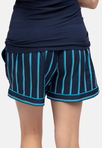 Marine gestreepte shorts met verticale witte en turquoise lijnen, gemaakt van gladde stof, met een contrasterende rand en een ontspannen pasvorm.
