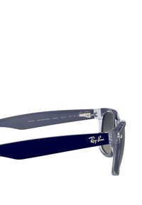 Occhiali da sole Ray-Ban con montatura grigia trasparente, stanghette blu scuro, lenti nere e dettagli in metallo argentato. Modello RB 2132, stile New Wayfarer.