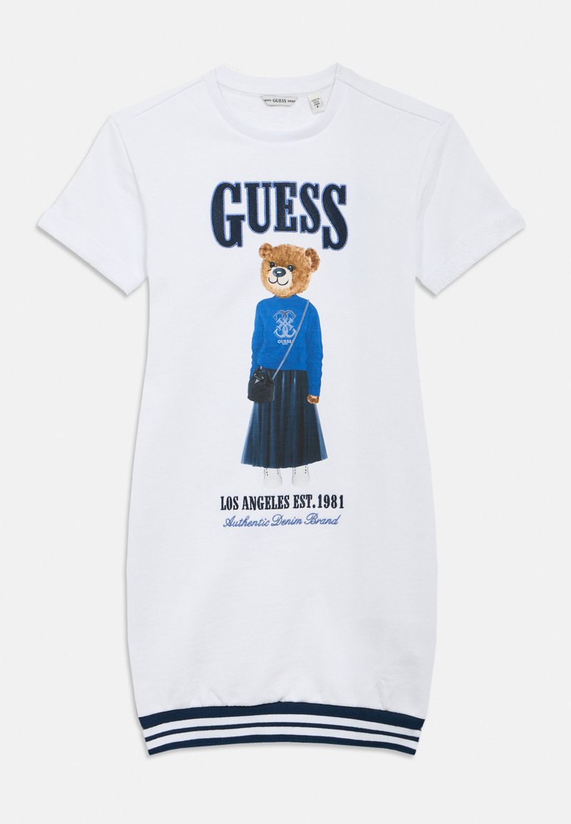 Λευκό φόρεμα με κοντά μανίκια που απεικονίζει έναν αρκούδο με μπλε πουλόβερ και κείμενο. Μανσέτες με ναυτικό ριγέ σχέδιο και μήκος μέχρι το γόνατο.