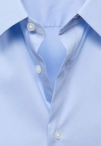 Lichtblauw katoen overhemd met een spitse kraag, voorzien van twee witte knopen bij de hals, een gladde textuur en een gestructureerd ontwerp.