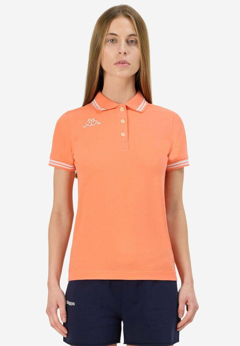 Polo arancione con colletto classico, tre bottoni e dettagli a righe bianche sulle maniche. Presenta un logo ricamato sul lato sinistro del petto.