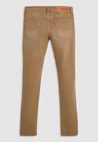 Jean droit marron en denim, avec deux poches arrière ornées de coutures et un patch en cuir de la marque sur la taille.