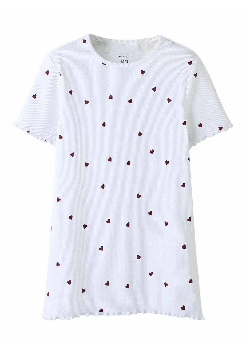 Camiseta blanca de manga corta con textura acanalada y pequeños patrones de corazones color marrón, con un dobladillo con volantes y escote redondo.