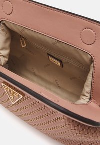 Różowa pleciona torebka z złotymi detalami, z gładką skórzaną wierzchnią warstwą oraz materiałowym wnętrzem, wytłoczona nazwą marki.