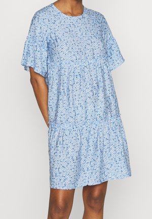 Robe florale bleue avec des manches à volants courtes, un col rond et un design en étages. Présente de petits motifs floraux blancs et noirs sur un tissu doux.