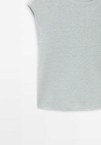 Vaaleanharmaa lyhythihainen t-paita, jossa on pehmeä rakenne ja rento istuvuus. Ominaisuuksiin kuuluvat pyöreä kaula-aukko ja hieman pudotetut olkapäät.