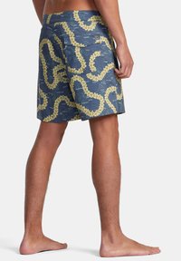 Herrbadshorts i marinblått med ett gult blommönster. Tillverkade av lätt material, med en bakficka och en avslappnad passform.
