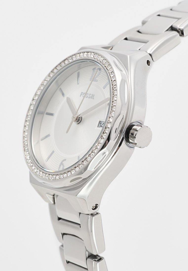 Orologio in acciaio inossidabile argento con quadrante rotondo, lunetta con accenti di cristallo, quadrante bianco, indici delle ore argentati e bracciale a maglie in metallo.