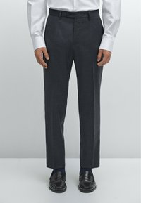 Dark gray tailored trousers with a straight fit, featuring a flat front, button closure, and side pockets. Paired with black loafers.