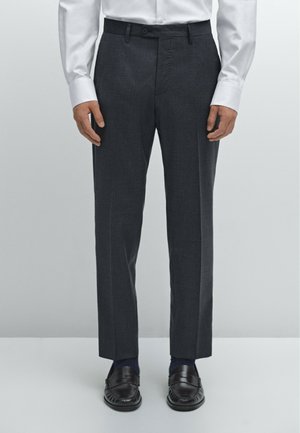 Dark gray tailored trousers with a straight fit, featuring a flat front, button closure, and side pockets. Paired with black loafers.
