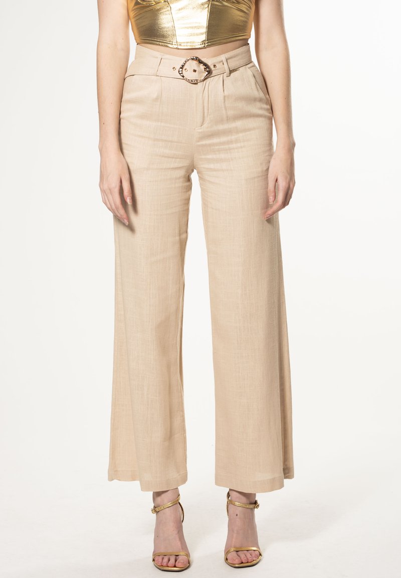 Beige weite Hosen mit strukturiertem Stoff, featuring einer hohen Taille und einem dekorativen Gürtel mit einer runden Schnalle und Nieten.