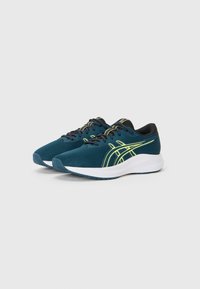 Des chaussures de sport teal avec une tige en maille texturée, des accents noirs et des détails jaunes vifs. Dotées d'une semelle intermédiaire blanche et d'une semelle extérieure en caoutchouc.