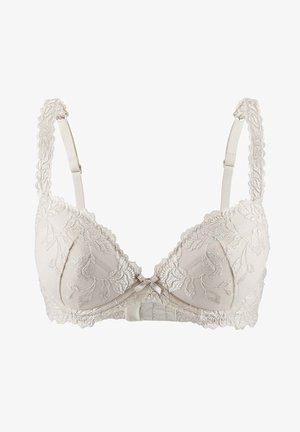 Soutien-gorge beige avec superposition en dentelle florale, bords festonnés et bretelles réglables. Accent nœud au centre et texture de tissu douce.