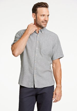 Camisa de botones de manga corta color gris claro con un bolsillo, hecha de una tela texturizada, que presenta un cuello y botones en contraste.