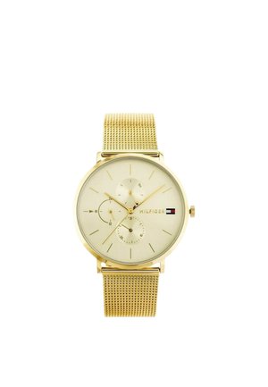 Reloj de pulsera con tono dorado, correa de malla, tres subesferas, marcadores de hora minimalistas y logo de Tommy Hilfiger en la esfera color crema.