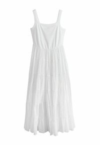 Robe maxi blanche sans manches avec corsage ajusté et jupe fluide à volants en tissu léger.