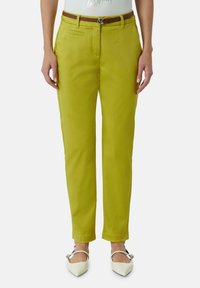 Limoengroene, op maat gemaakte broek met een slim fit, voorzien van zijzakken en een leren bruine riem. Glanzende stof met een gladde textuur.