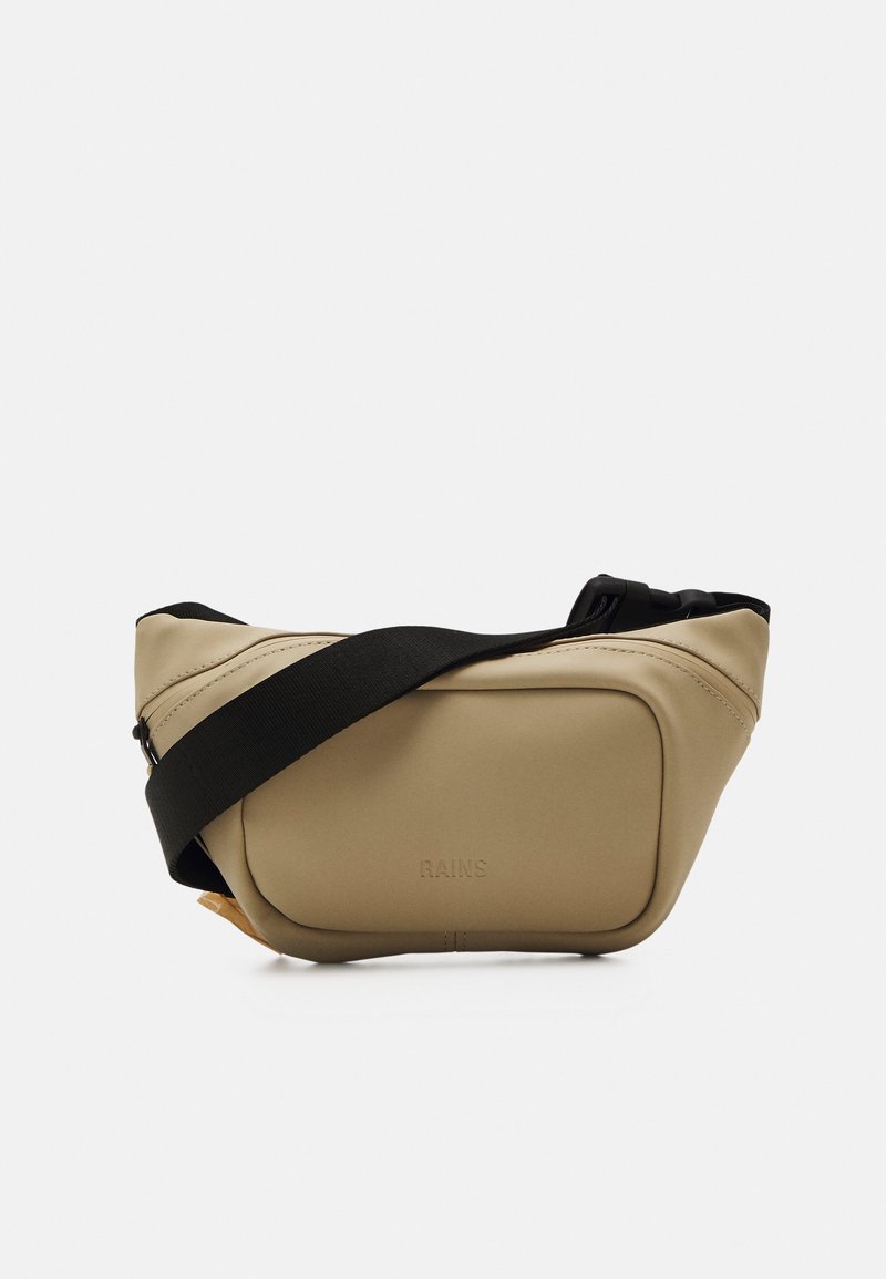 Sac bandoulière beige en matériau imperméable. Il dispose d'une bandoulière noire réglable et d'un design simple et arrondi avec une fermeture zippée.