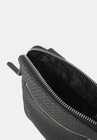 Borsa pochette nera con texture, con zip argentata, caratterizzata da un esterno a motivo e una fodera interna con branding. Forma compatta e rettangolare.