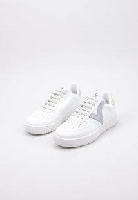 Baskets en cuir blanc avec des détails perforés, une touche de suède violet clair et des onglets de talon verts. Semelle en caoutchouc avec une adhérence texturée.