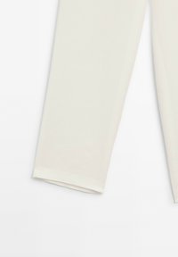 Light beige cropped trousers made of soft fabric, featuring a straight leg design with a clean hem and no visible embellishments.