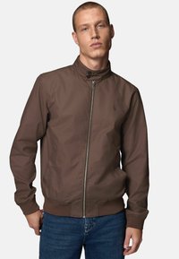 Veste bomber zippée marron avec col montant, poignets élastiques et poches latérales. Texture lisse et design minimaliste.