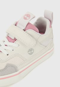 Lys grå sneakers med rosa detaljer, laget av semsket skinn og mesh-materialer, borrelåsstropp, hvite snorer og logo på siden.