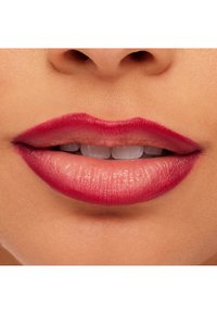 Lepper med en dyp rosa farge med en glansfull finish, distinkt kontur og subtil gradient mot midten, satt mot glatt hud.