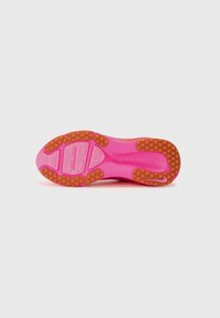 Semelle extérieure de chaussure de sport en rose vif avec une surface texturée, présentant des motifs d'adhérence en caoutchouc marron et des détails de logo intégrés.