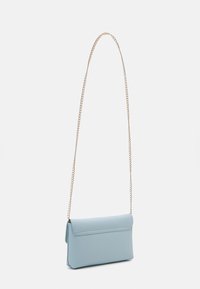 Světle modrá crossbody taška vyrobená z hladkého materiálu s překlopným uzávěrem, vybavená zlatým řetízkem a minimalistickým designem.