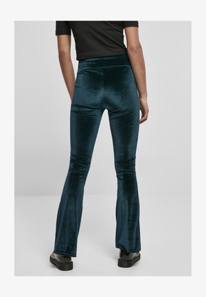 Teal, velvet flared pants with a high waist, smooth texture, and subtle sheen. Elastic waistband, fitted through thighs and flared at the hem.