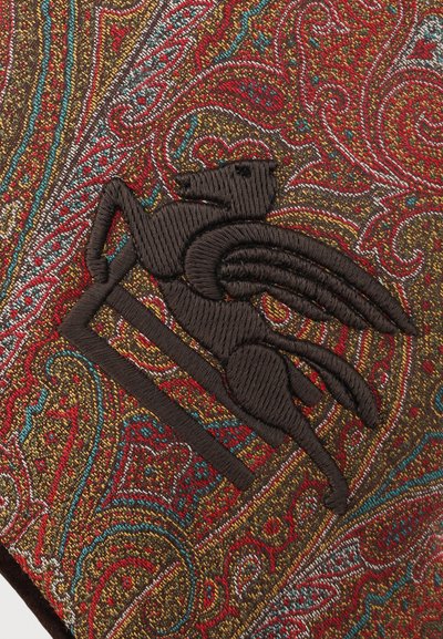 Broderie détaillée d'un cheval ailé brun foncé sur un tissu richement orné de motifs cachemire rouges, dorés, bleus et blancs.