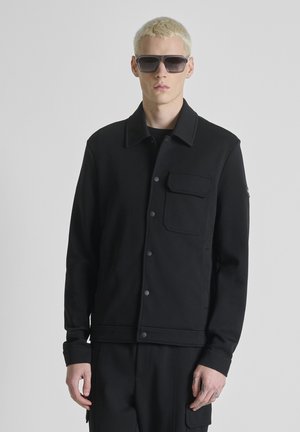 WITH LOGO PLATE - Lichte jas - black